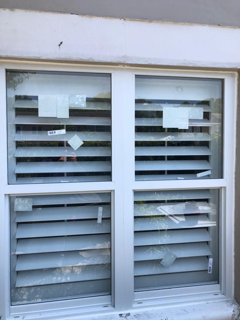 Colonial style grille between the glass impact windows installed on a traditional Florida home adding architectural detail and curb appeal