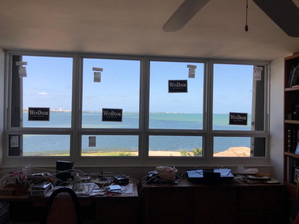Elegant hurricane rated French doors installed on a luxury home in Miami Beach Florida with decorative glass panels and tropical landscaping