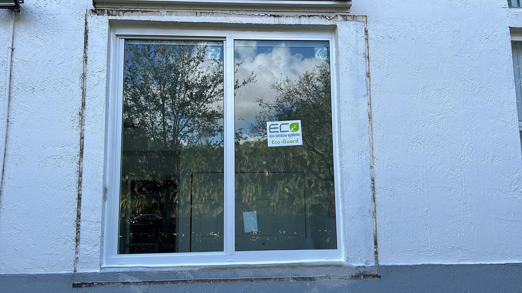 High resolution photo of completed impact window installation project at a Florida property showing exterior view of new windows