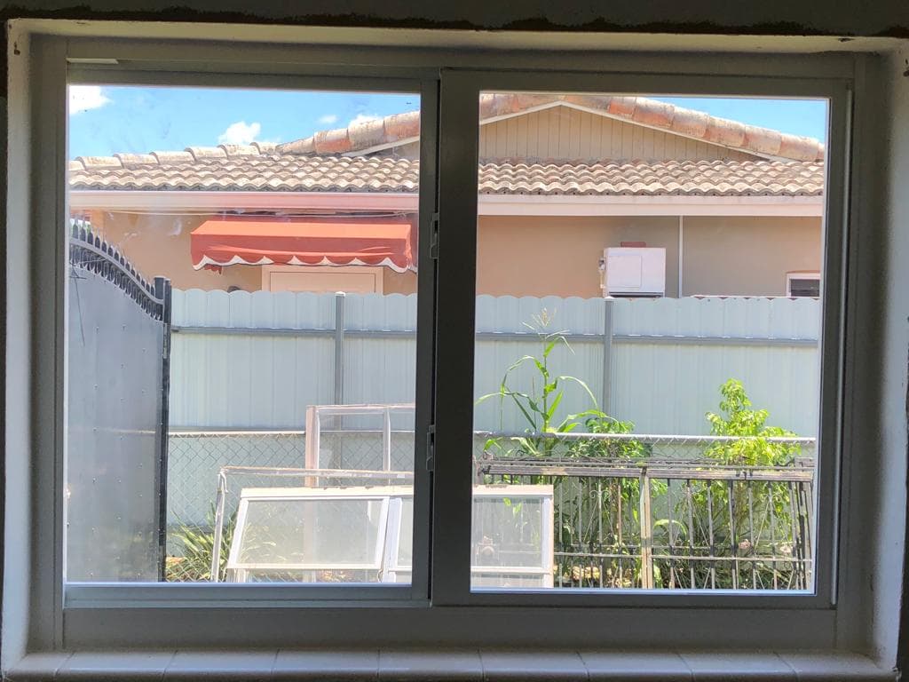 Quality check photo of completed impact window installation on a Florida home showing proper operation and alignment of window sashes