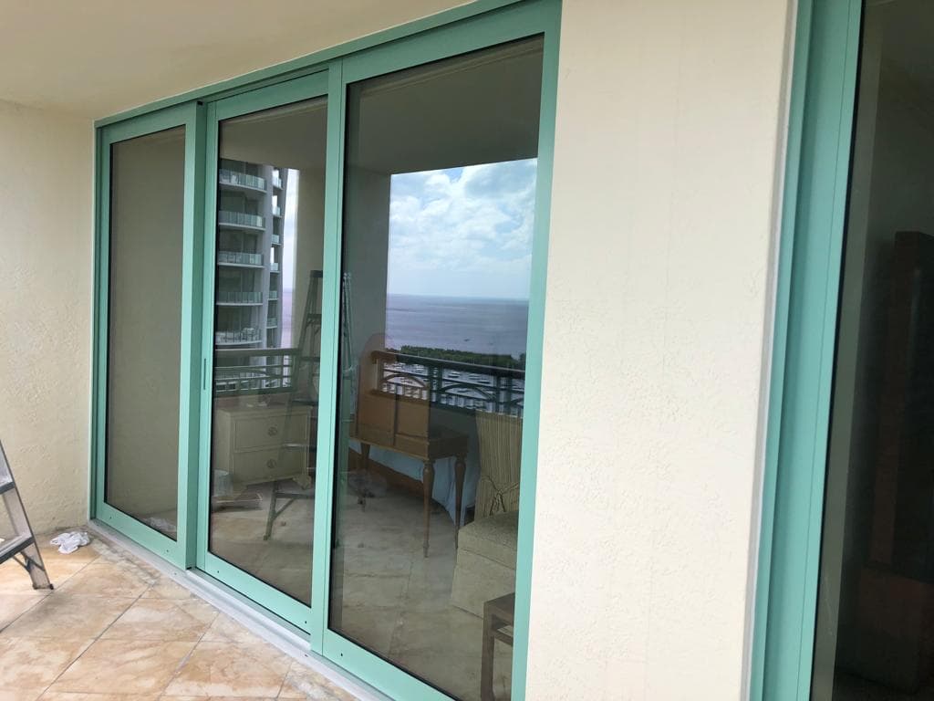 Certified window installation team working on a Florida home installing impact windows with professional equipment and safety gear