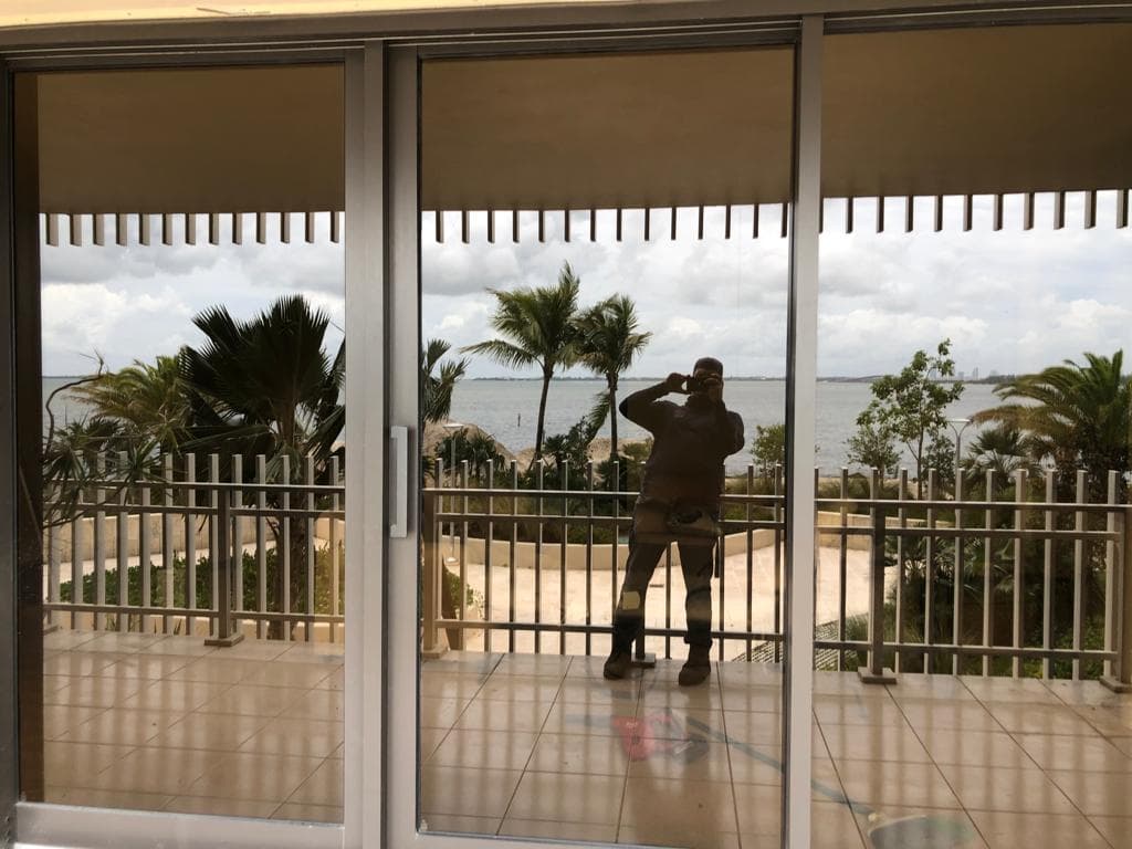 Complete window replacement project on a tropical home in Coconut Grove Miami with new hurricane impact windows and lush landscaping
